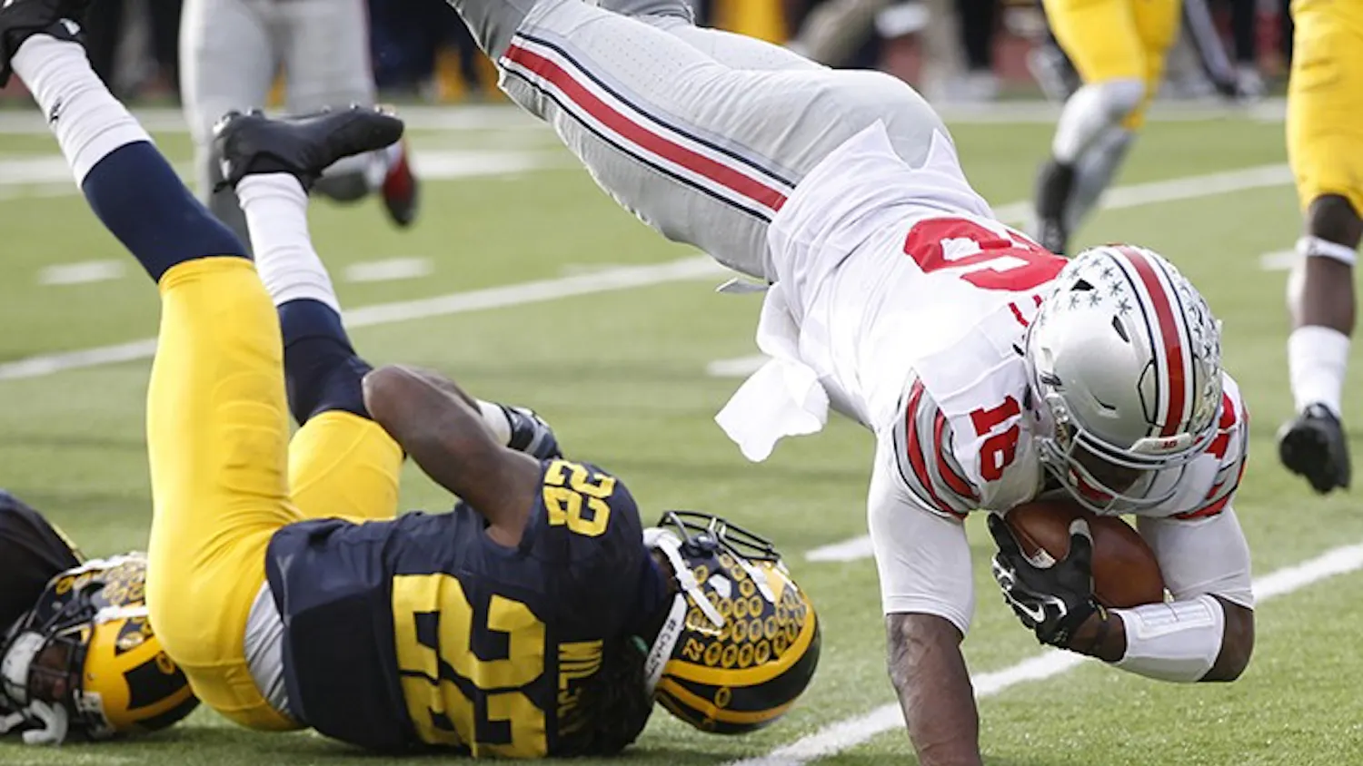 Ohio State quarterback J.T. Barrett, right, leaps over Michigan's Jarrod Wilson and into the end zone for a third-quarter touchdown on Saturday, Nov. 28, 2015, at Michigan Stadium in Ann Arbor, Mich. Ohio State won, 42-13. (Julian H. Gonzalez/Detroit Free Press/TNS)