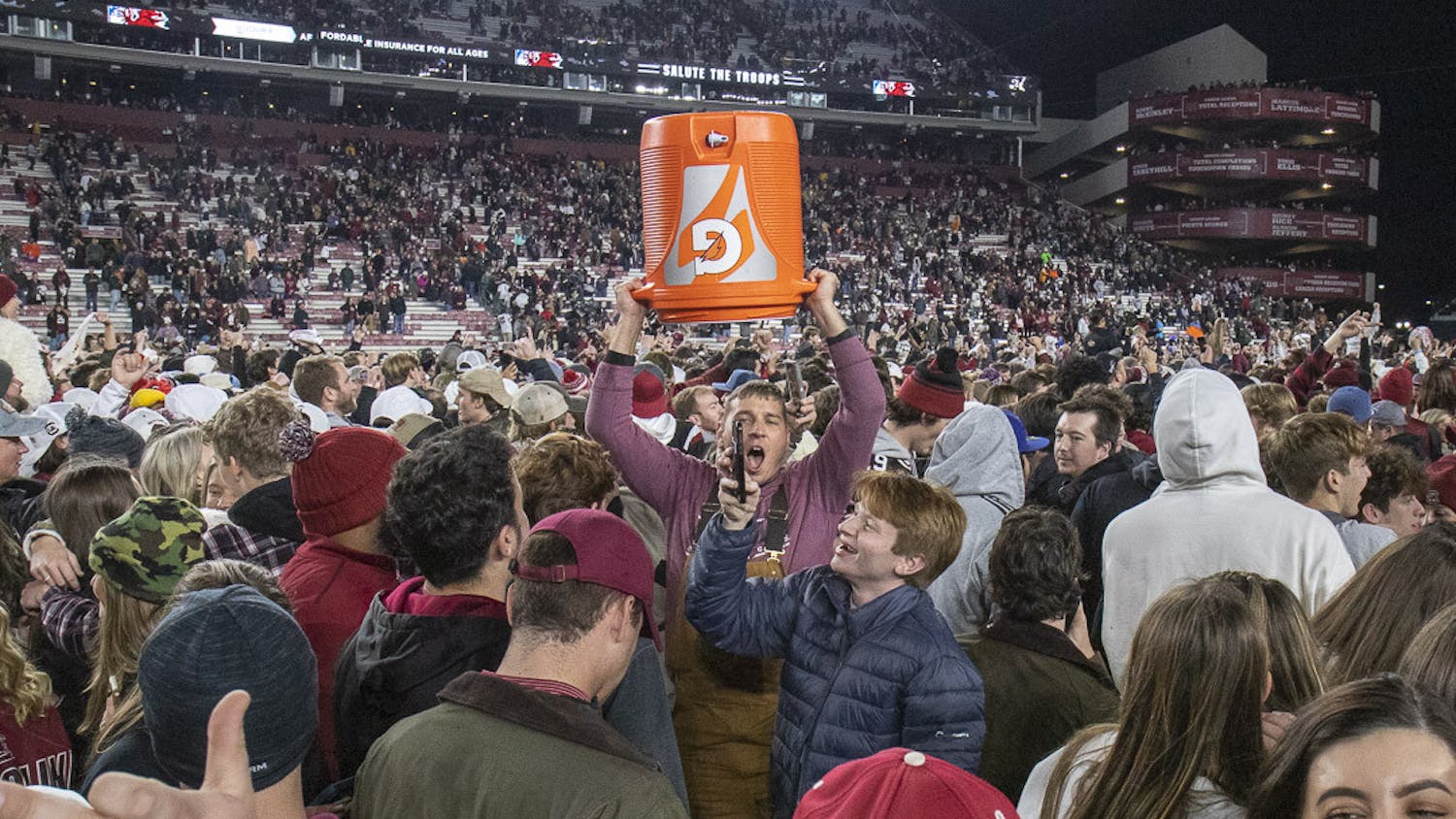 FILE—A South Carolina fan raises the Gatorade jug used to douse Gamecock head football coach Shane Beamer into the air after the 63-38 upset against Tennessee at Williams-Brice Stadium on Nov. 19, 2023. Gamecock students and fans rushed the field en masse after the unanticipated win over the Volunteers.