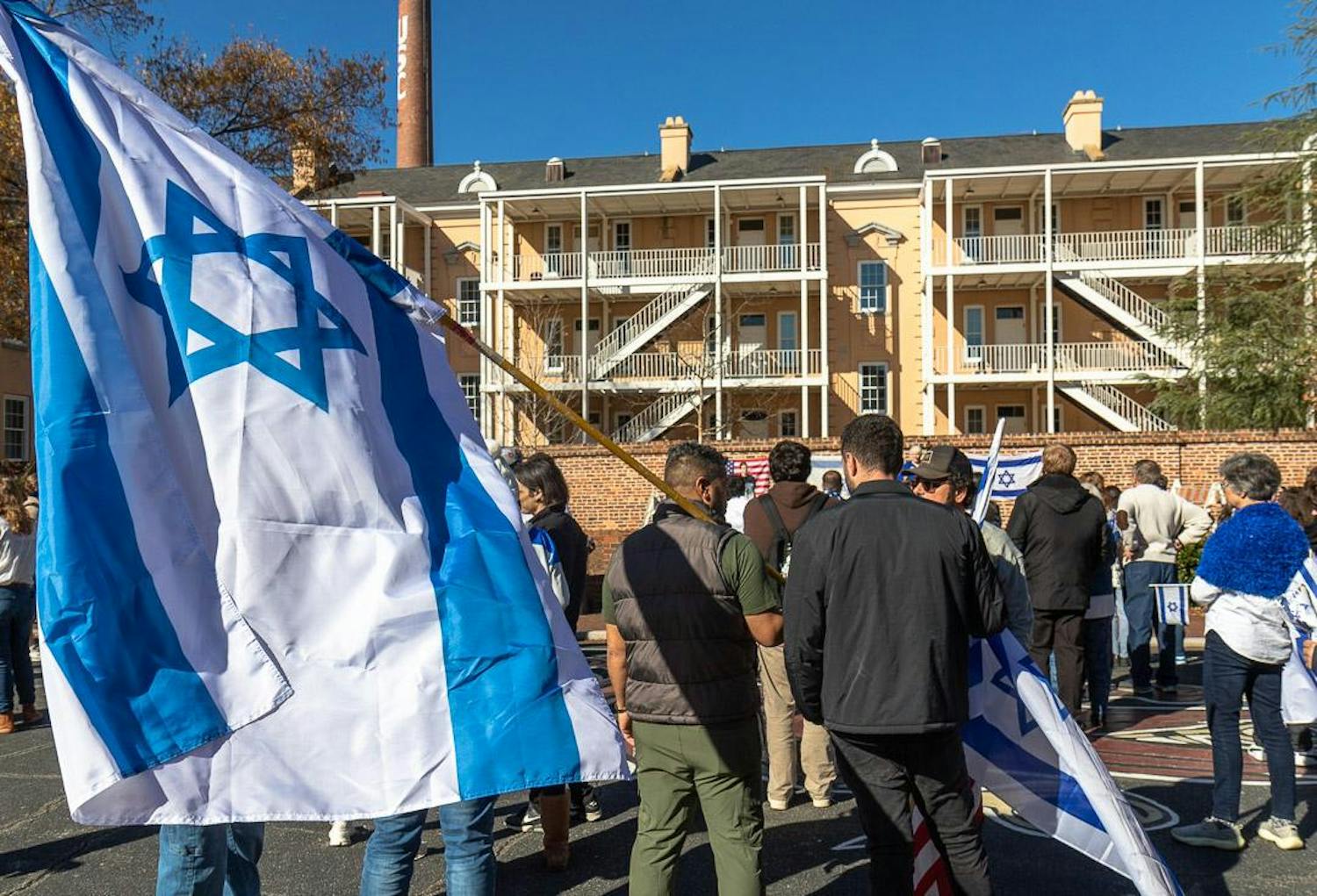 An attendee carries an Israeli flag during the pro-Israel rally on Greene Street on Dec. 7, 2023. Jewish locals and allies came out to support during the rally, calling for an end to violence in Gaza.