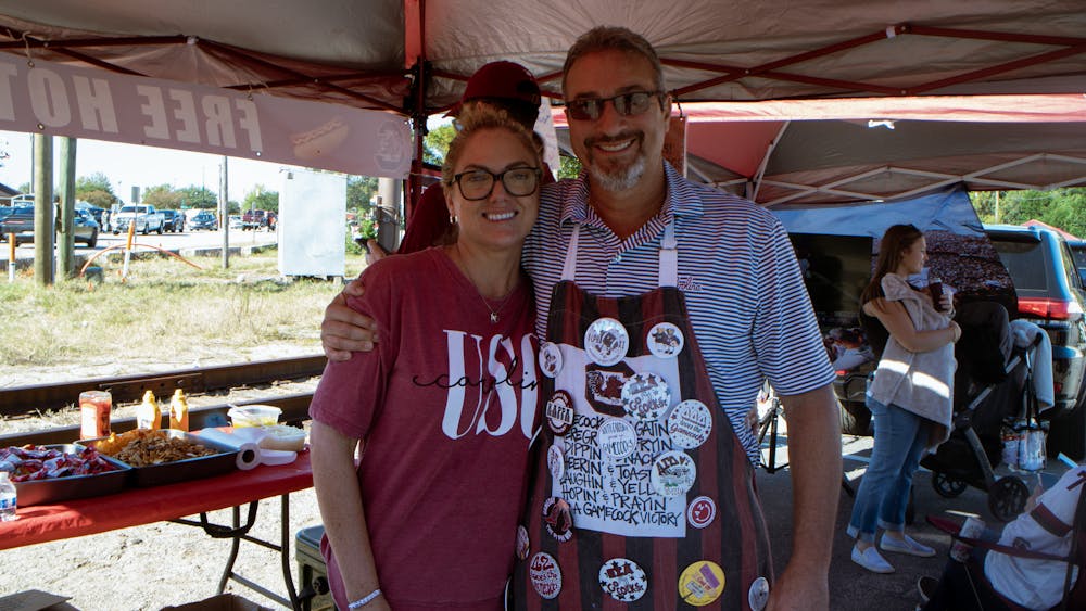 <p>Chris and Dominique Crawford at their tailgate spot near the fraternity lots outside of Williams-Brice Stadium. The Crawfords hand out free hotdogs to students before every South Carolina home game.</p>