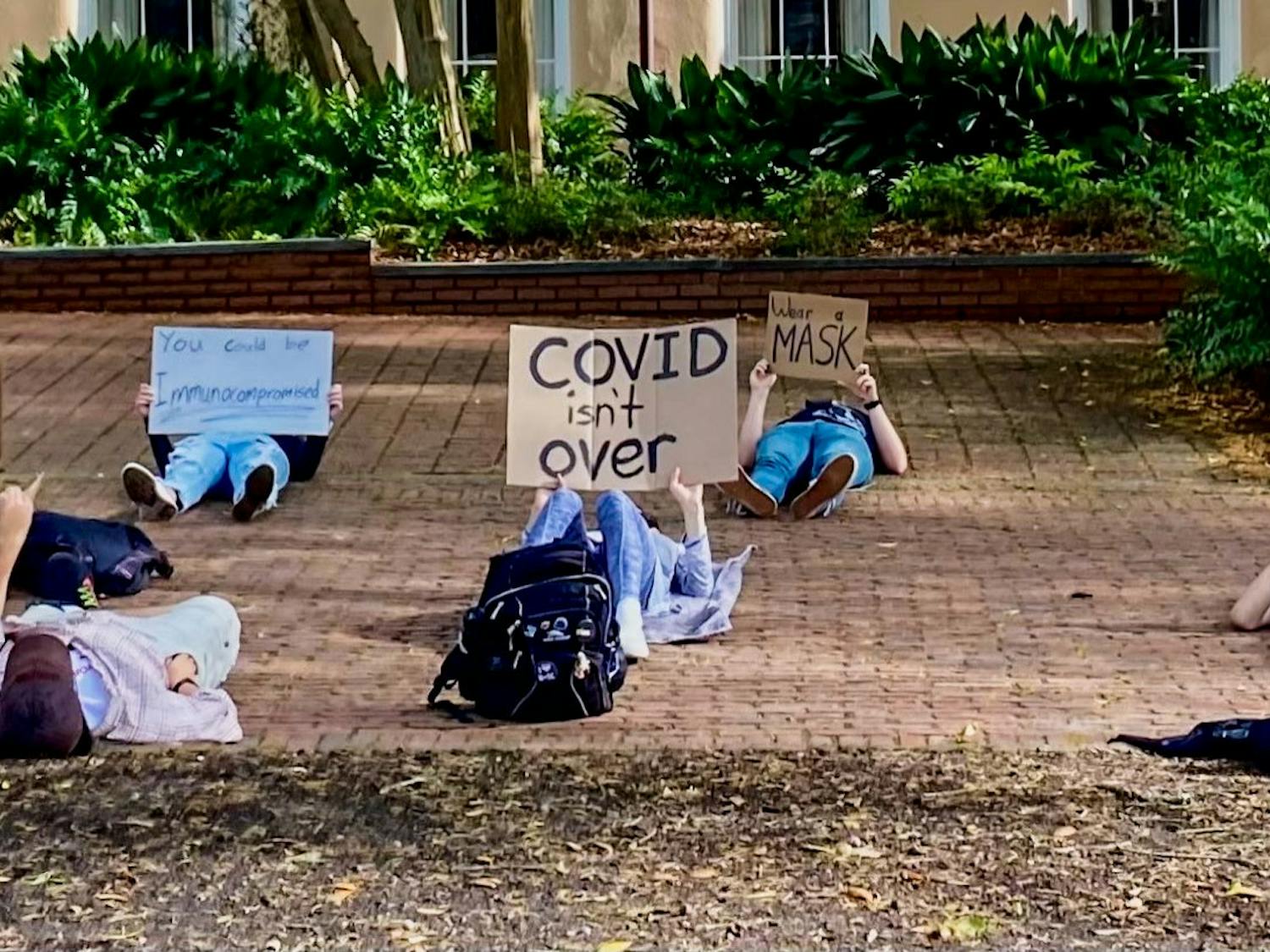 Student protesters hold a "die down" demonstration, laying down in silence to honor those who have lost their life to COVID, during pro-mask protest on March 31, 2022. Pro-mask protesters gathered in the horseshoe to protest the removal of the school's mask mandate.
