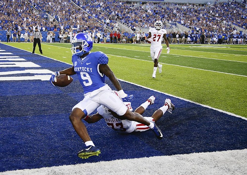 Kentucky Wildcats receiver Garrett Johnson (9) goes in for a first quarter touchdown on a Patrick Towles pass over Louisiana-Lafayette Ragin Cajuns defensive back Zachary DeGrange (33) as Kentucky played Louisiana-Lafayette on Saturday, Sept. 5, 2015 in Lexington, Ky. (Mark Cornelison/Lexington Herald-Leader/TNS) 