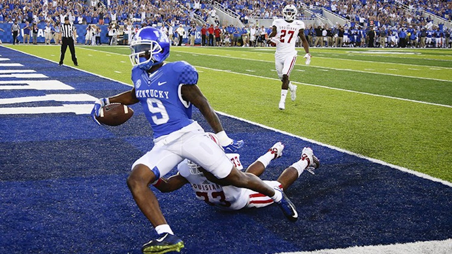 Kentucky Wildcats receiver Garrett Johnson (9) goes in for a first quarter touchdown on a Patrick Towles pass over Louisiana-Lafayette Ragin Cajuns defensive back Zachary DeGrange (33) as Kentucky played Louisiana-Lafayette on Saturday, Sept. 5, 2015 in Lexington, Ky. (Mark Cornelison/Lexington Herald-Leader/TNS)