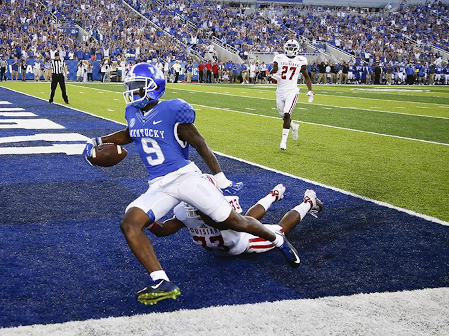 Kentucky Wildcats receiver Garrett Johnson (9) goes in for a first quarter touchdown on a Patrick Towles pass over Louisiana-Lafayette Ragin Cajuns defensive back Zachary DeGrange (33) as Kentucky played Louisiana-Lafayette on Saturday, Sept. 5, 2015 in Lexington, Ky. (Mark Cornelison/Lexington Herald-Leader/TNS)