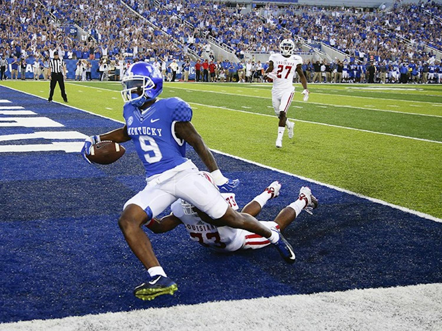 Kentucky Wildcats receiver Garrett Johnson (9) goes in for a first quarter touchdown on a Patrick Towles pass over Louisiana-Lafayette Ragin Cajuns defensive back Zachary DeGrange (33) as Kentucky played Louisiana-Lafayette on Saturday, Sept. 5, 2015 in Lexington, Ky. (Mark Cornelison/Lexington Herald-Leader/TNS) 