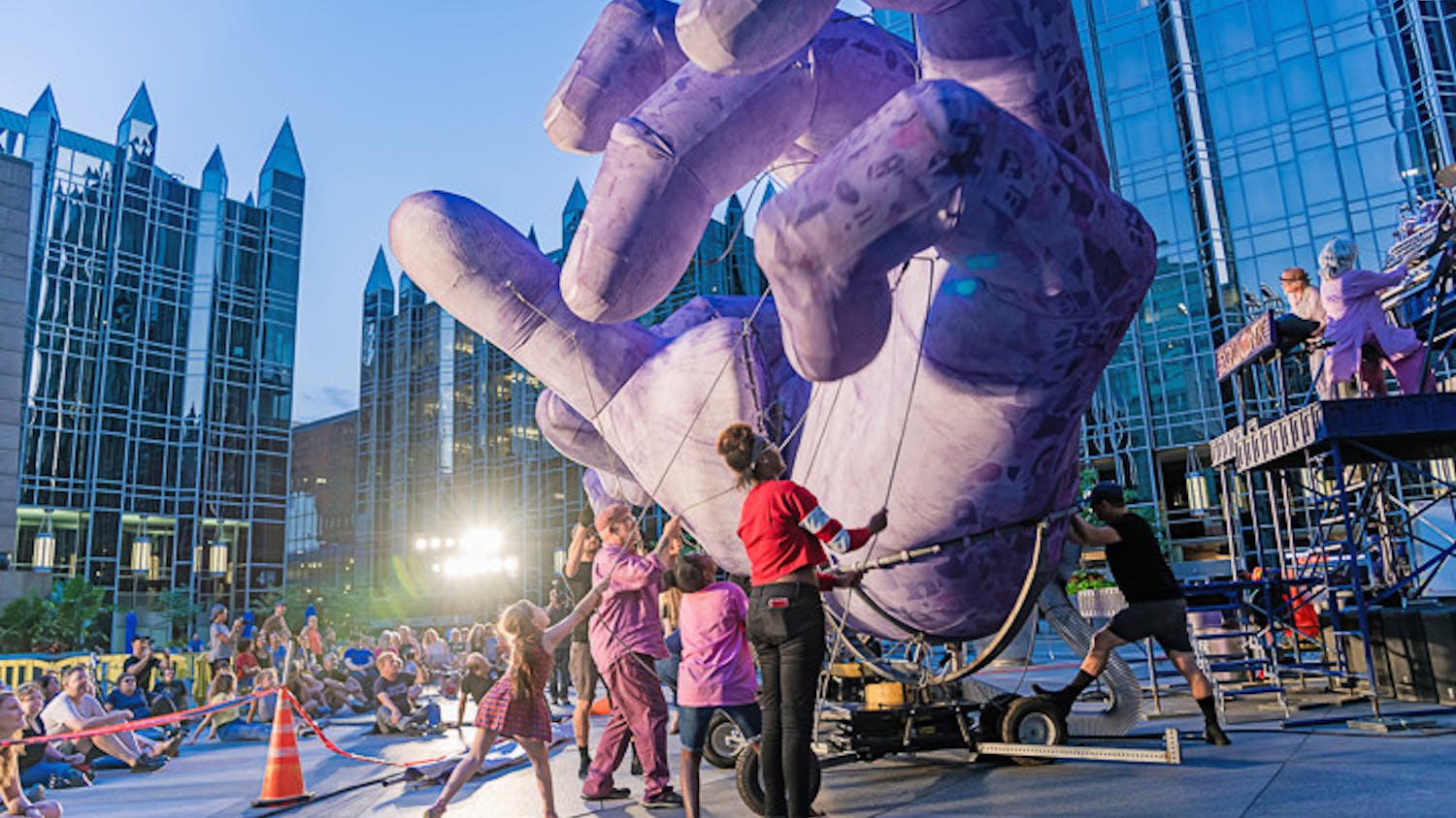 Musicians from the band Squonk and audience members work together to manipulate the purple hands during the band's 'Hand to Hand' performance on their 2019 tour.