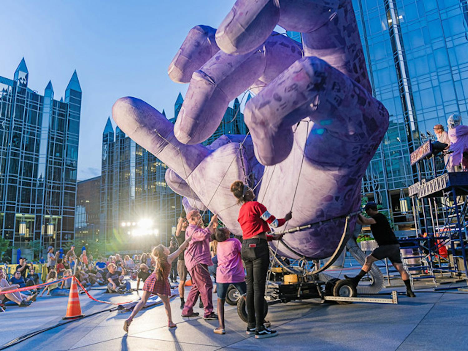 Musicians from the band Squonk and audience members work together to manipulate the purple hands during the band's 'Hand to Hand' performance on their 2019 tour.