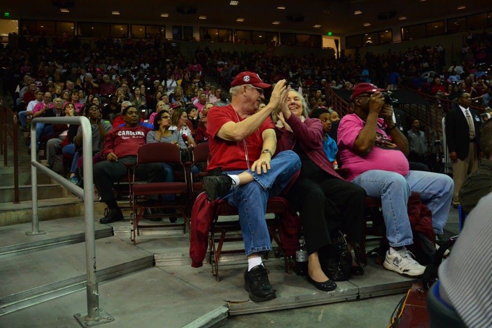 Tom and Betsy Donald of Ridgeway, SC celebrate with a high-five as the Lady Gamecocks score a three-pointer and maintain their lead over the Georgia Bulldogs during the third quarter. South Carolina Gamecocks vs Georgia Bulldogs. Colonial Life Arena, Columbia, SC. February 18, 2016