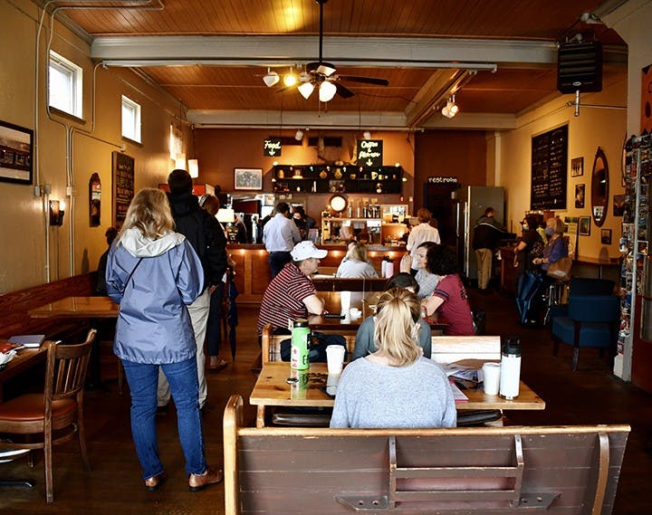 Customers wait in line for their order at Immaculate Consumption while other customers enjoy their orders in the provided seating.