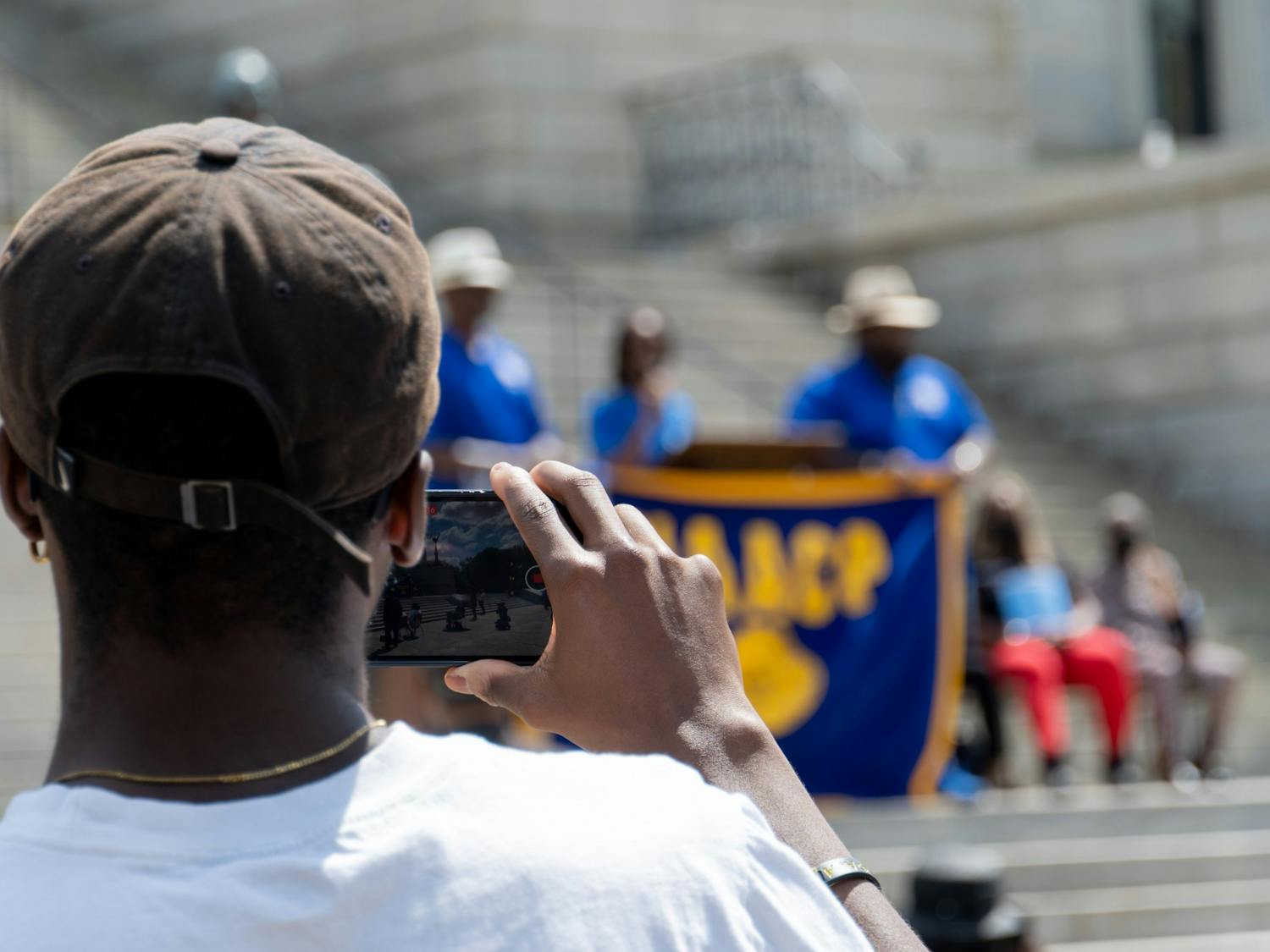 A rally attendee takes a picture during a speech by Courtney McClain, the Youth and College President for the NAACP chapter at the University of South Carolina on April 23, 2022. "I think we just need far, far, far more young people ... just getting involved in these issues and taking more direct action," McClain said.