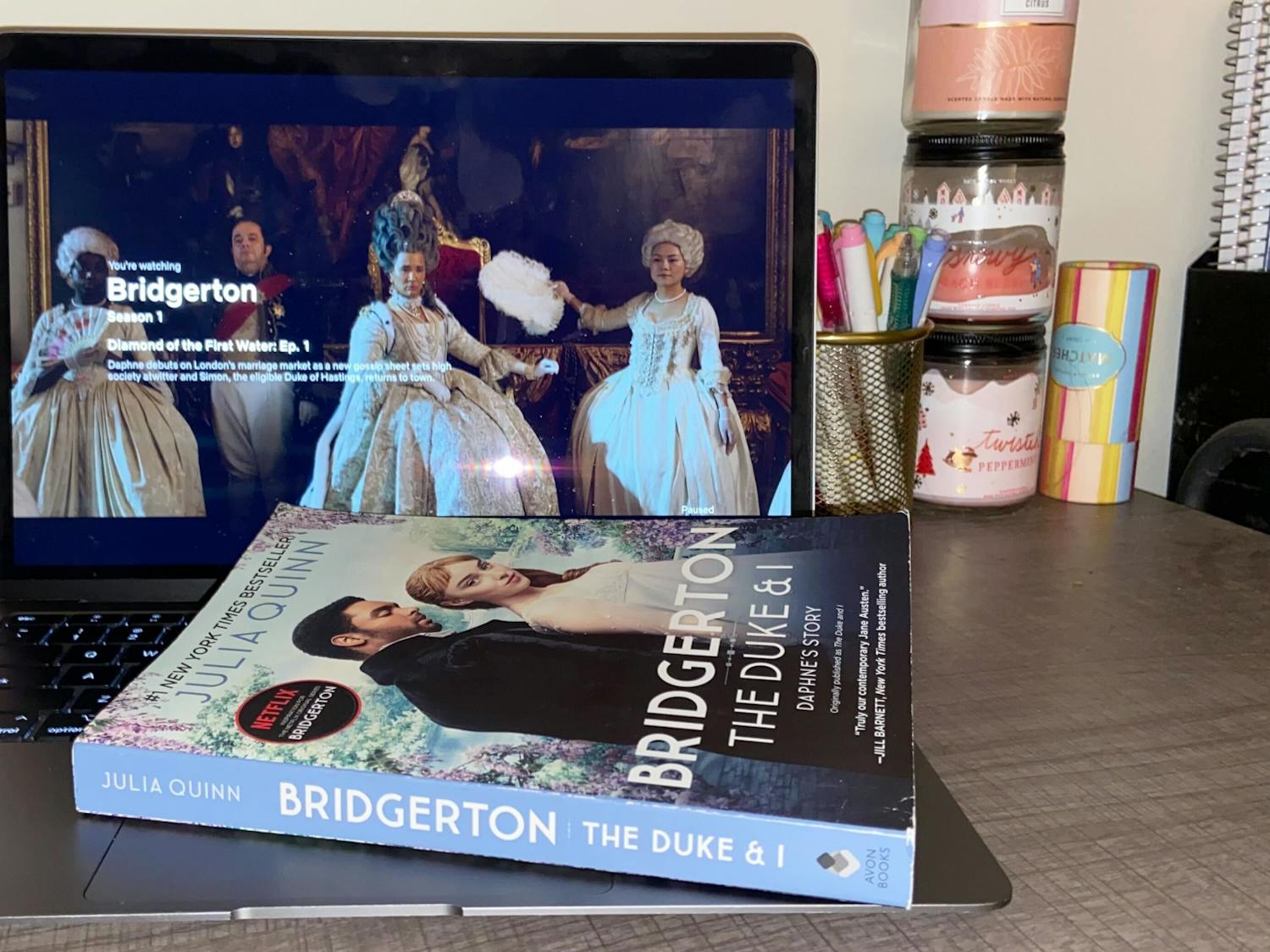 The first Bridgerton book sits on top of a laptop playing the first episode of its TV adaptation. The first season of Bridgerton was released on Dec. 25, 2020.