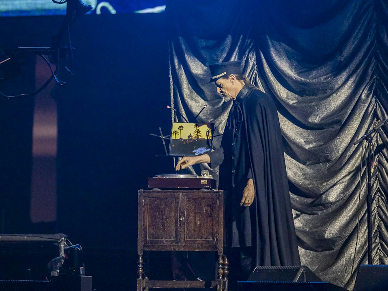 A cast member dressed in a cloak and bellhop costume places the "Hotel California" vinyl on a record player to kick off the Eagles concert on March 30, 2023, at Colonial Life Arena. The band opened up the show with its hit song, "Hotel California."