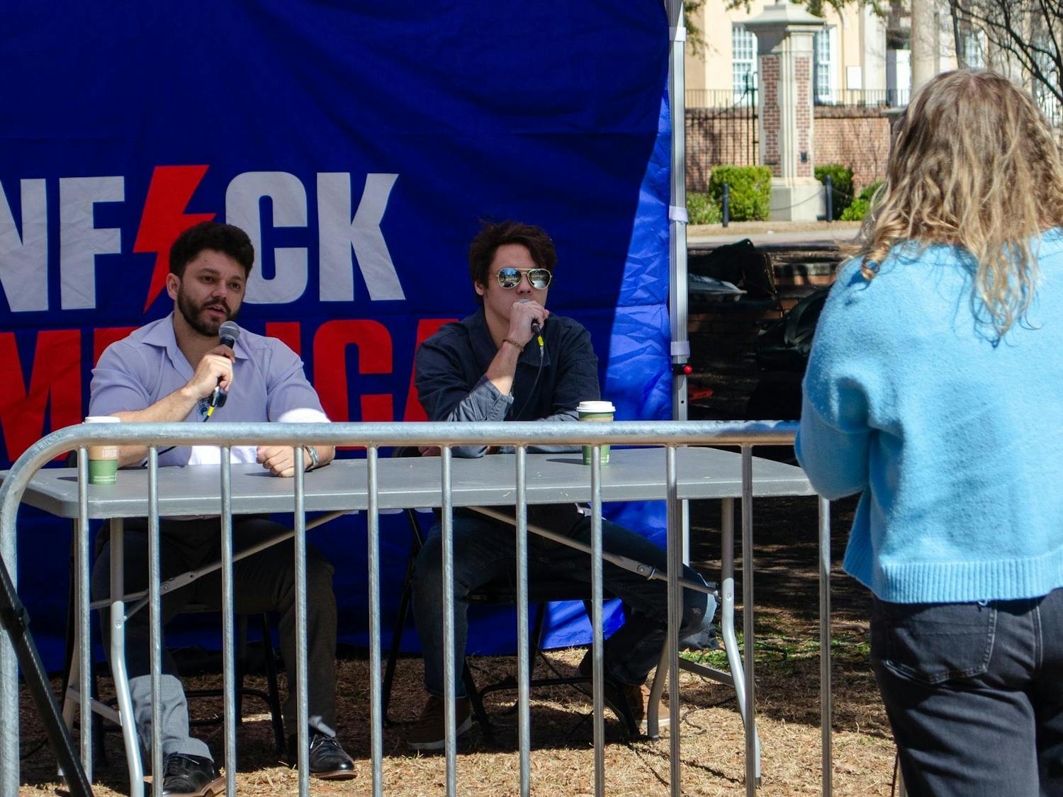 Carly Smith, a second-year public health student, debates Corbin Joseph and Ethan Alexander on abortion policy at an Unfuck America Tour event on Davis Field on Feb. 13, 2026. Both are content creators with the Unfuck America Tour, which is organized by National Ground Game.