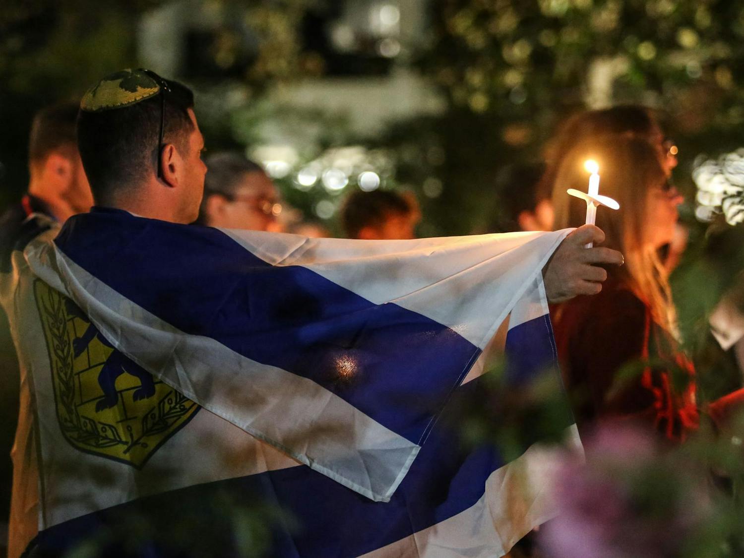 A man carries the flag of Jerusalem in the garden of the Anne Frank Center at the University of South Carolina during a Jewish community vigil for Israel on Oct. 17, 2023. The vigil was hosted by Gamecocks for Israel, Hillel at UofSC, Alpha Epsilon Pi, Chabad on Campus and the University of South Carolina.