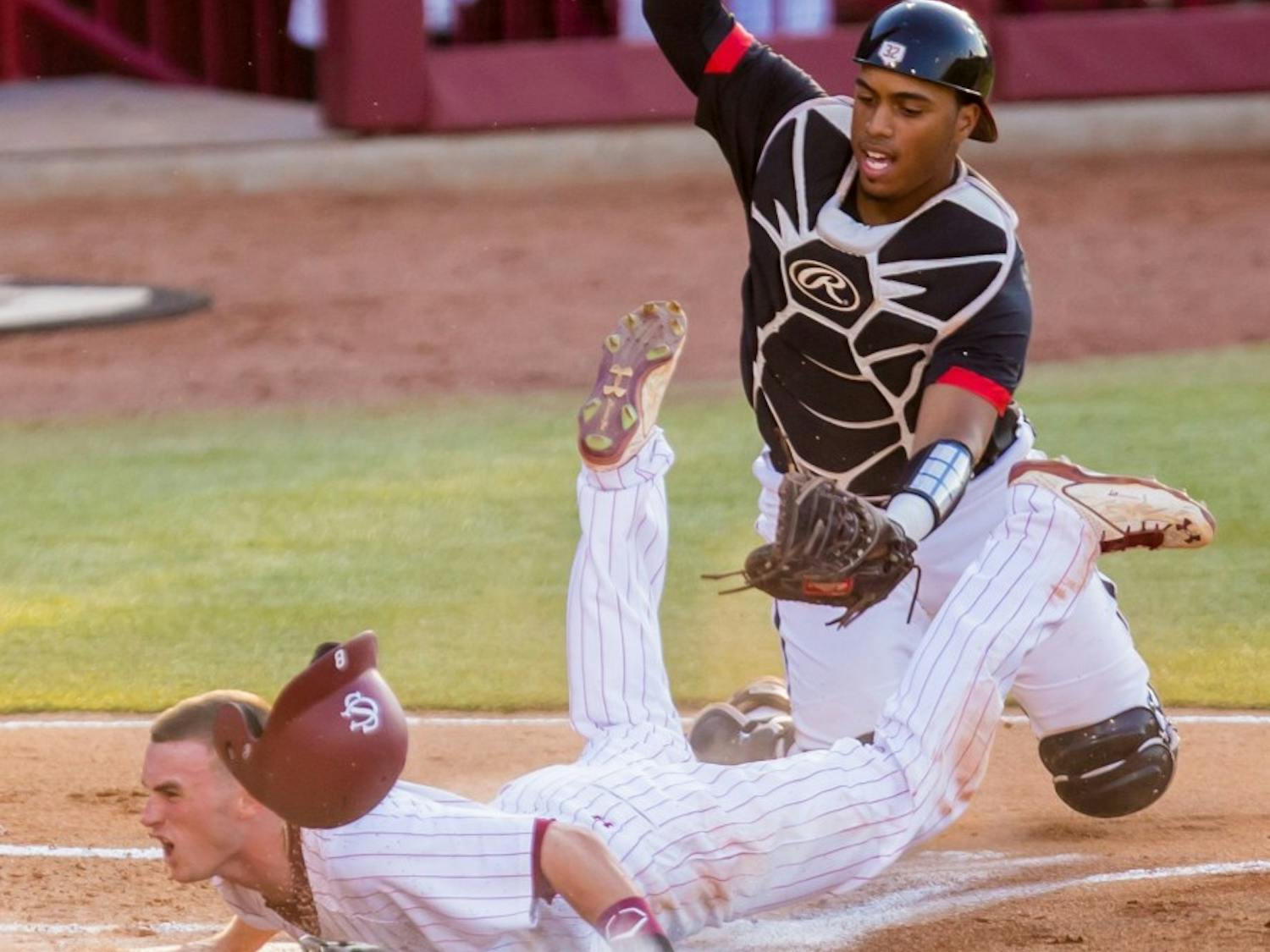 South Carolina shortstop Marcus Mooney (8) scores ahead of the tag of Maryland catcher Kevin Martir (32) on Sunday, June 1, 2014, in Columbia, S.C. Maryland won 10-1. (Jeff Blake/The State/MCT)