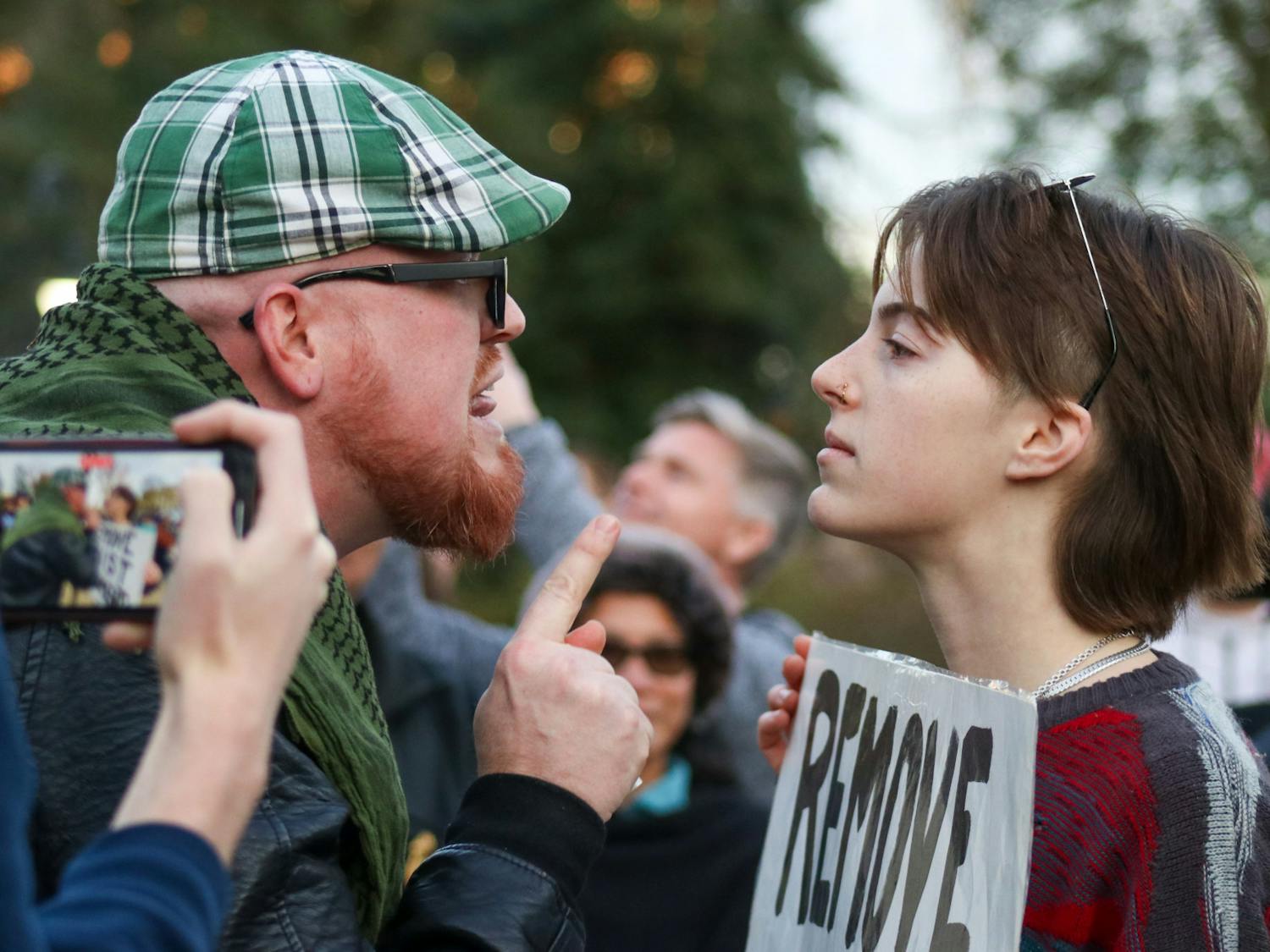 Attendee JT Bessinger (left) and protestor and third-year media arts student Katelynn Basile (right) engage in a verbal altercation with each other at the Statehouse on Jan. 28, 2023. A crowd gathered outside of the Statehouse on Saturday as former President Donald Trump spoke inside to invitees and members of the media.