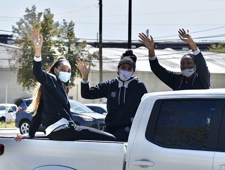 Junior forward Victaria Saxton, sophomore guard Brea Beal and sophomore forward Aliyah Boston wave at fans from the back of a truck that drove them in a procession-like fashion around the Colonial Life Arena parking lot.