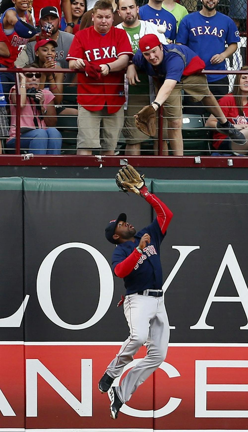 Center fielder Jackie Bradley Jr. of the Boston Red Sox makes a play on a ball hit by Prince Fielder of the Texas Rangers as a fan tries to make his own catch  on Friday, May 9, 2014, in Arlington, Texas. (Ron Jenkins/Fort Worth Star-Telegram/MCT)