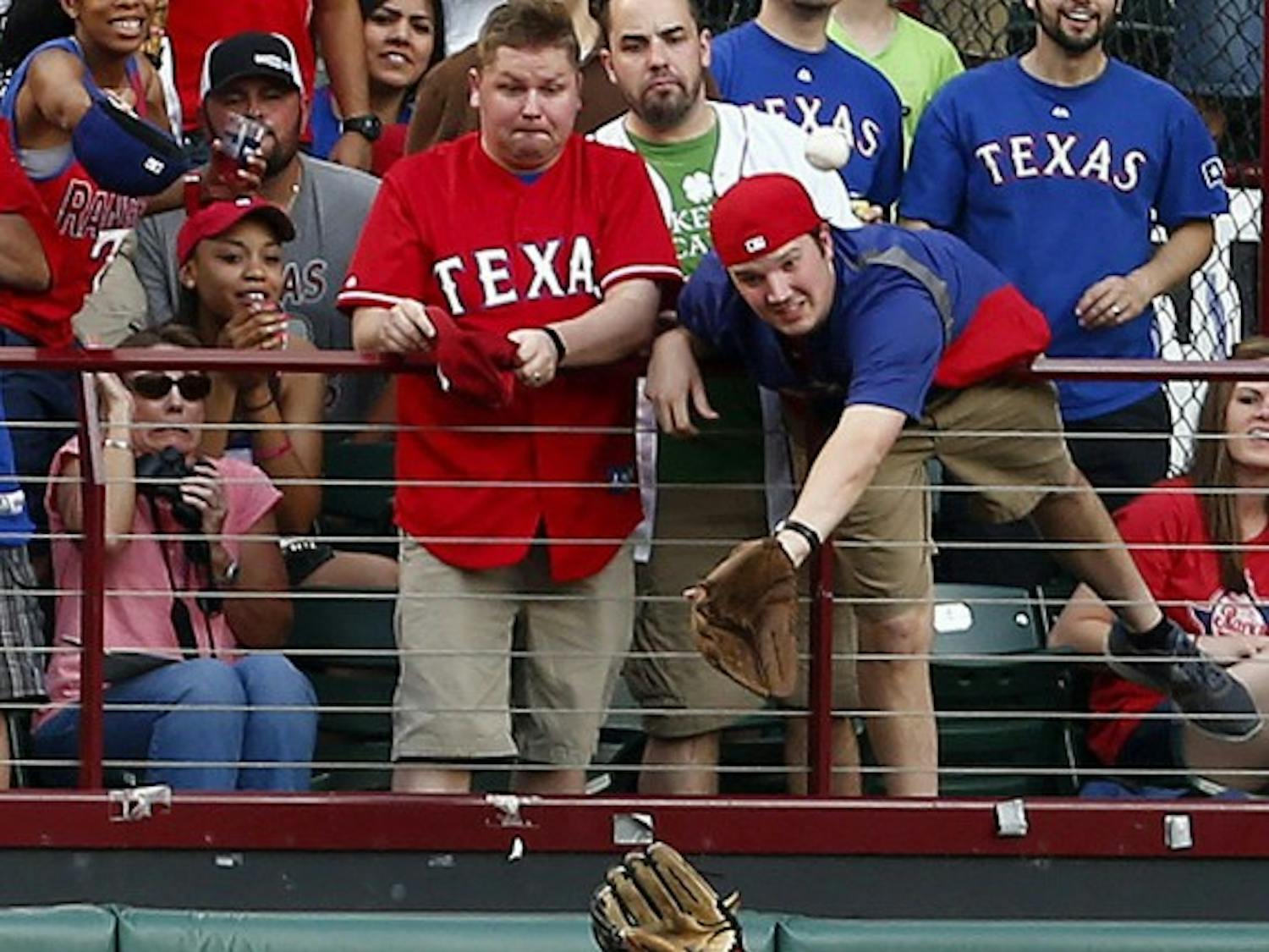 Center fielder Jackie Bradley Jr. of the Boston Red Sox makes a play on a ball hit by Prince Fielder of the Texas Rangers as a fan tries to make his own catch on Friday, May 9, 2014, in Arlington, Texas. (Ron Jenkins/Fort Worth Star-Telegram/MCT)