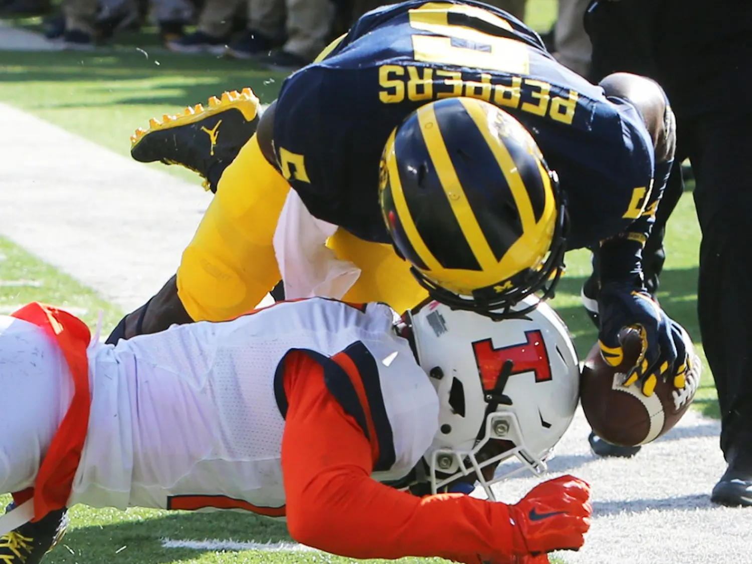 Michigan's Jabrill Peppers (5) is tackled by Illinois' Stanley Green in the first quarter on Saturday, Oct. 22, 2016, at Michigan Stadium in Ann Arbor, Mich. The host Wolverines won, 41-8. (Kirthmon F. Dozier/Detroit Free Press/TNS)