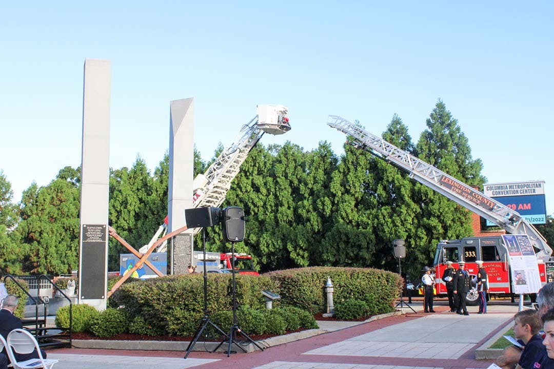 A Columbia City Fire tower and a Lexington County Fire ladder flank the 9/11 Memorial outside the Columbia Metropolitan Convention Center on Sept. 11, 2022. The monument was dedicated in 2011 and includes two steel beams from the World Trade Center.