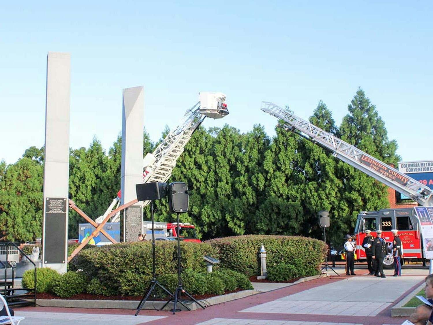 A Columbia City Fire tower and a Lexington County Fire ladder flank the 9/11 Memorial outside the Columbia Metropolitan Convention Center on Sept. 11, 2022. The monument was dedicated in 2011 and includes two steel beams from the World Trade Center.