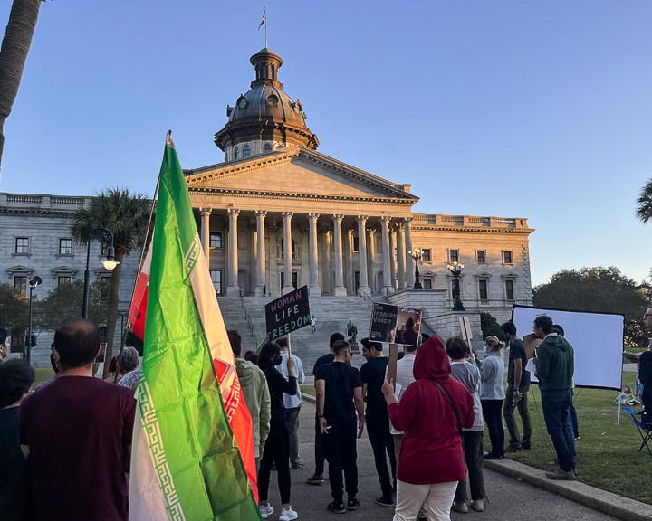 Columbia residents gather in front of the statehouse with Iranian flags and protest signs on Oct. 4, 2022. The USC Iranian Student Association held a protest at the statehouse to show solidarity with their country's women.