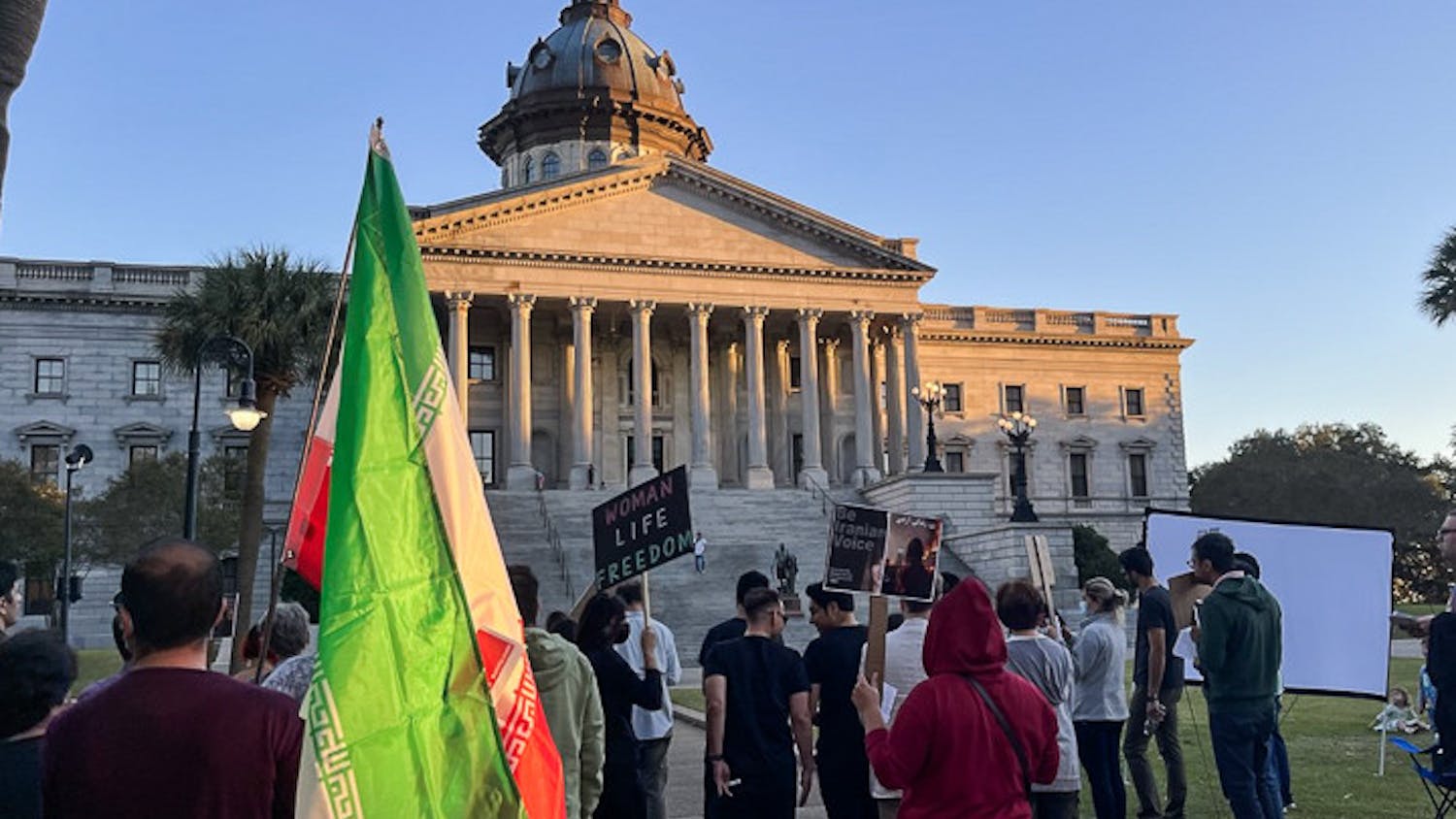 Columbia residents gather in front of the statehouse with Iranian flags and protest signs on Oct. 4, 2022. The USC Iranian Student Association held a protest at the statehouse to show solidarity with their country's women.