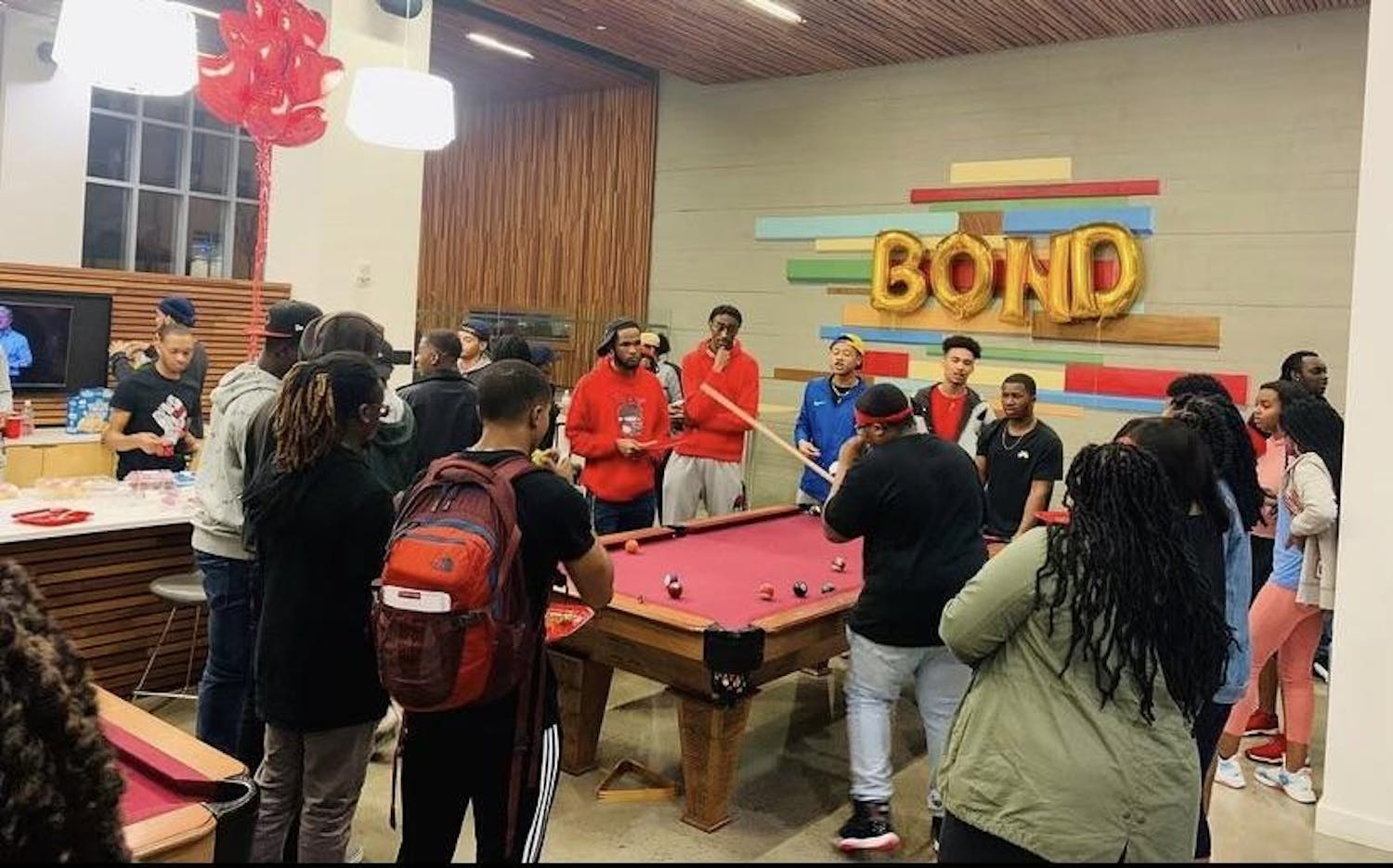 Members of Brothers of Nubian Descent, or BOND, are pictured congregating around a pool table during an organization event. The organization is open to all men of color at the University of South Carolina, and it promotes unity and retention intending to enhance the Black male experience on campus.