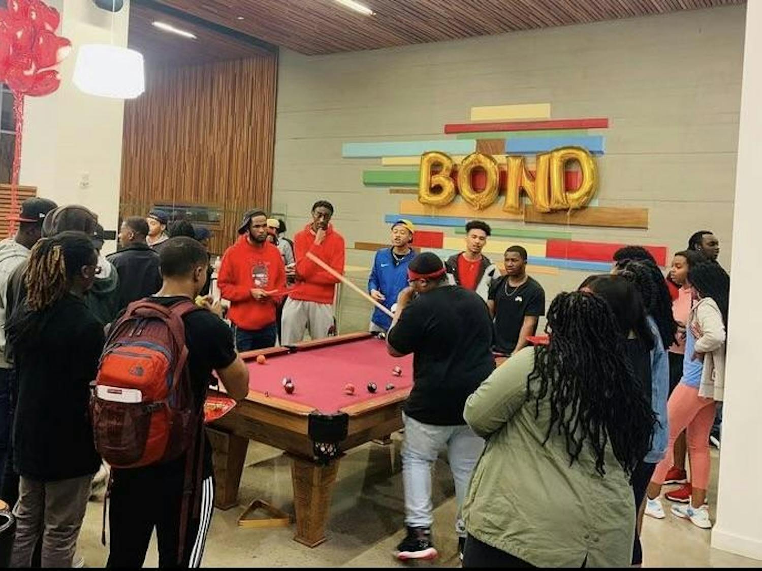Members of Brothers of Nubian Descent, or BOND, are pictured congregating around a pool table during an organization event. The organization is open to all men of color at the University of South Carolina, and it promotes unity and retention intending to enhance the Black male experience on campus.
