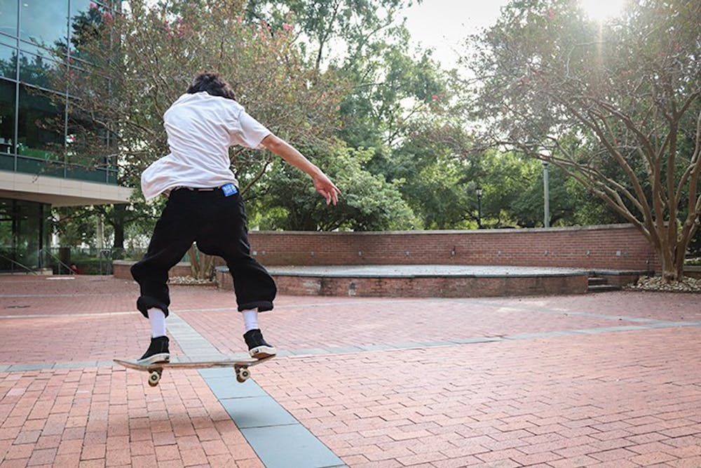 <p>A member of the Gamecock Skate Club performs a trick on the Russell House patio.&nbsp;</p>