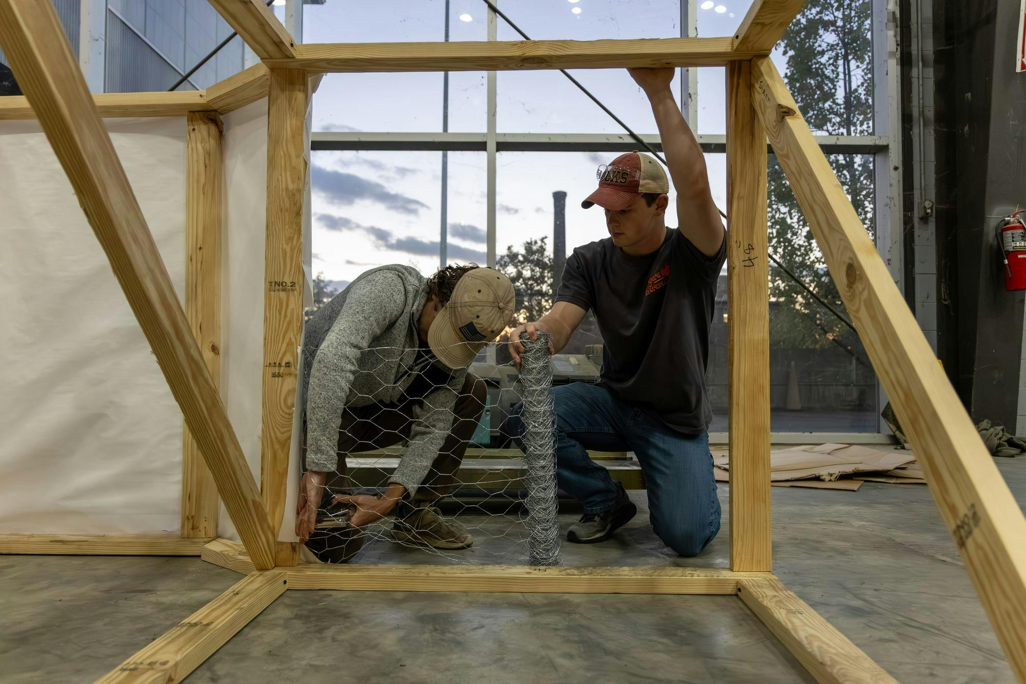 Two South Carolina students and members of the American Society of Mechanical Engineers place wire mesh over a section of the tiger statue for Tiger Burn on Nov. 10, 2025. ASME has been building the tiger's structure for 22 years.