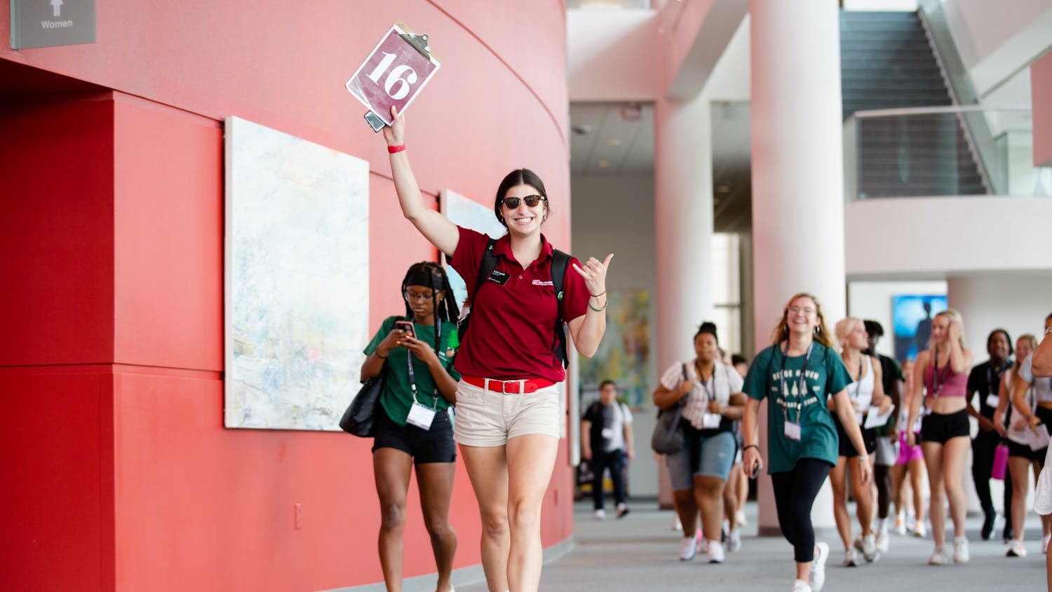 An orientation leader holds up a clipboard listing her group number as she leads new students to their first activity on July 20, 2022. Upperclassmen lead first-year students through two-day orientation sessions to help introduce them to USC and prepare them for their freshman year.