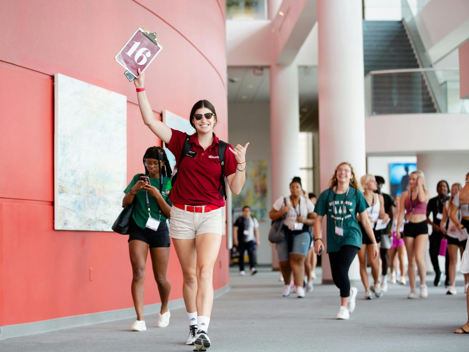 An orientation leader holds up a clipboard listing her group number as she leads new students to their first activity on July 20, 2022. Upperclassmen lead first-year students through two-day orientation sessions to help introduce them to USC and prepare them for their freshman year.