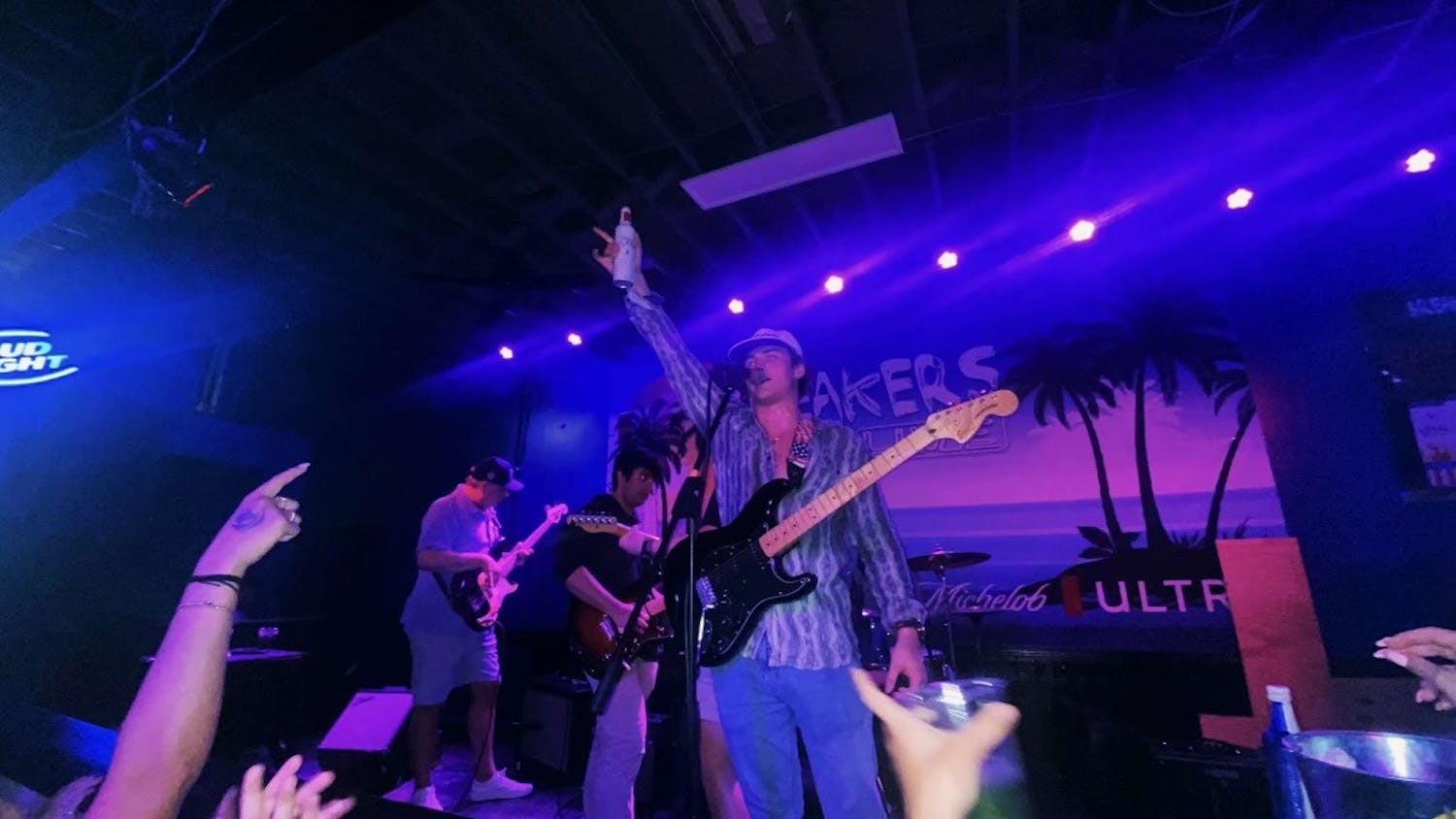 Lead vocalist Jack Brecher raises his drink to a crowd as the band prepares for its next song at Breaker’s Live in Five Points on March 26, 2023. The group has been performing live at venues since February 2023. 