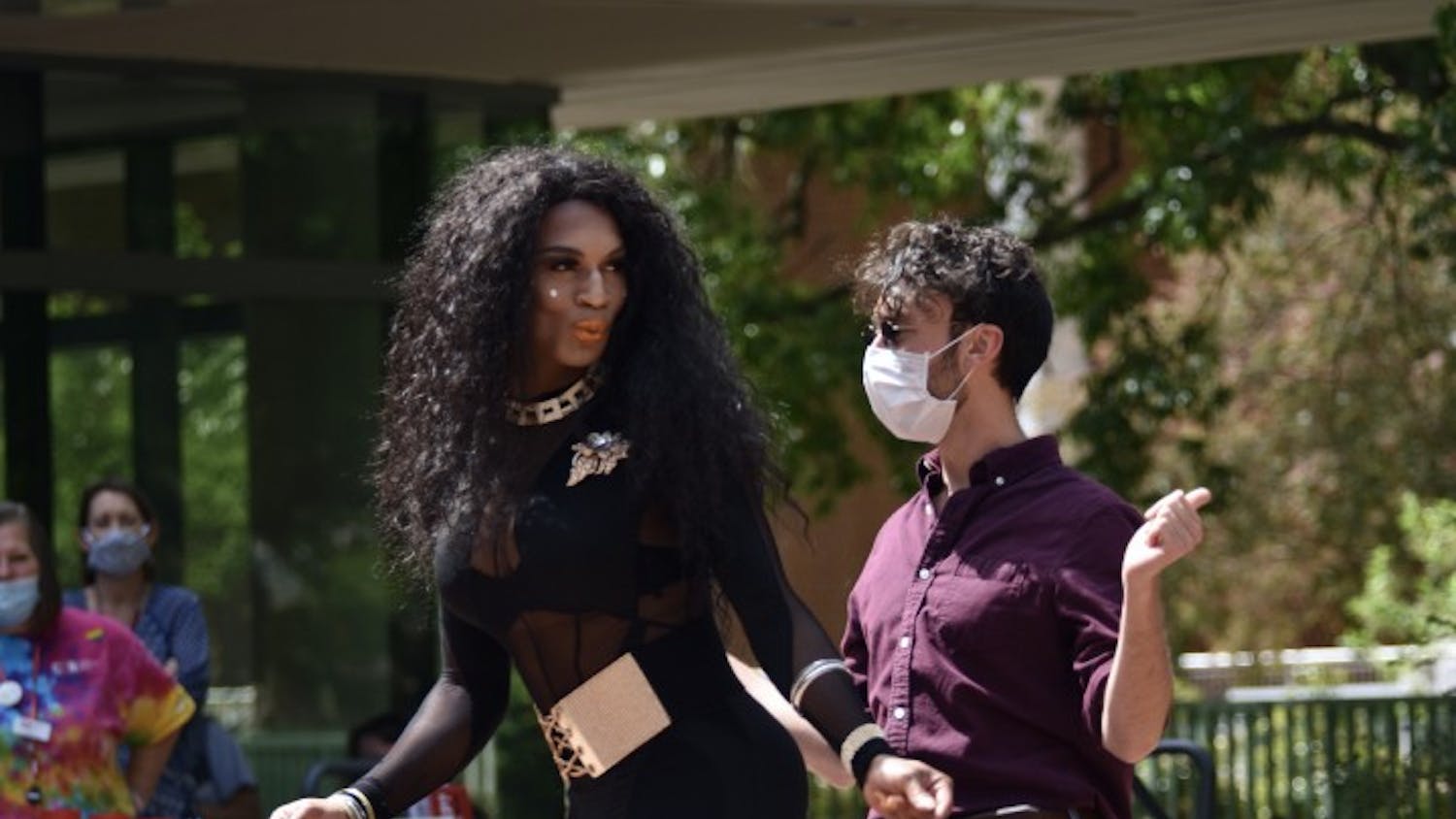 Drag queen Ava Drew Braxton invites a member of her audience at Pridechella to the center of the event.