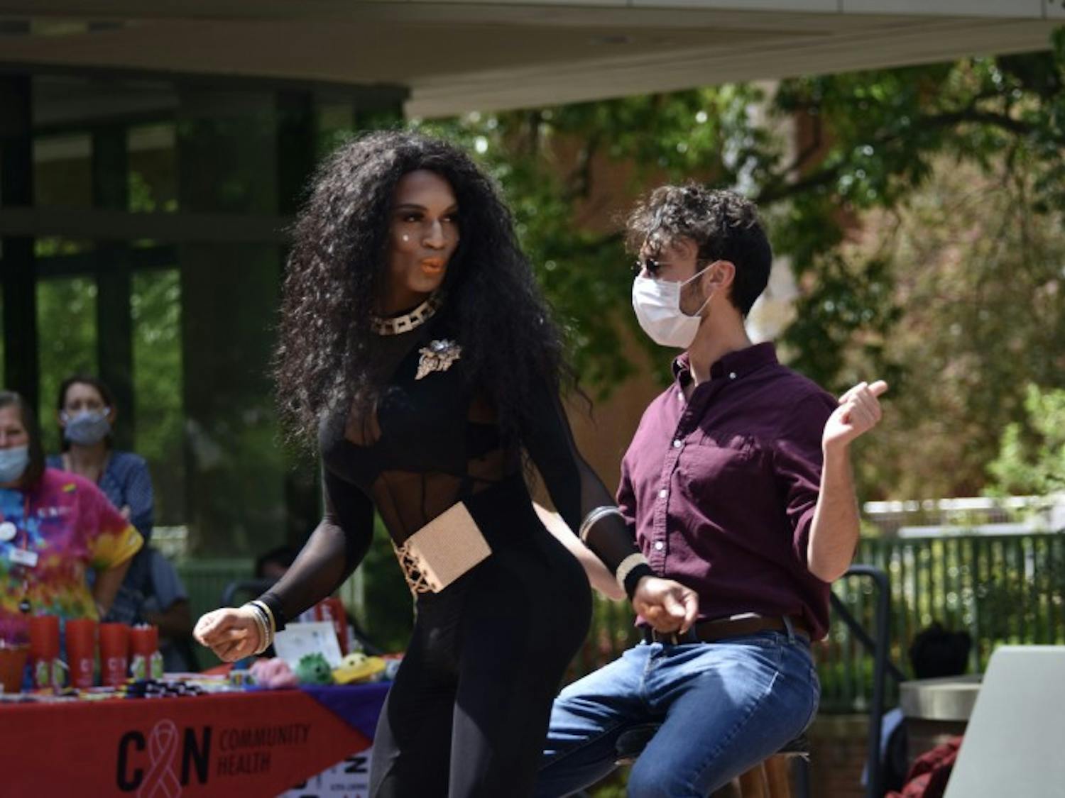 Drag queen Ava Drew Braxton invites a member of her audience at Pridechella to the center of the event.