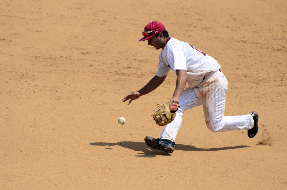 Max Schrock fumbles with the ball before throwing it to first for an out.