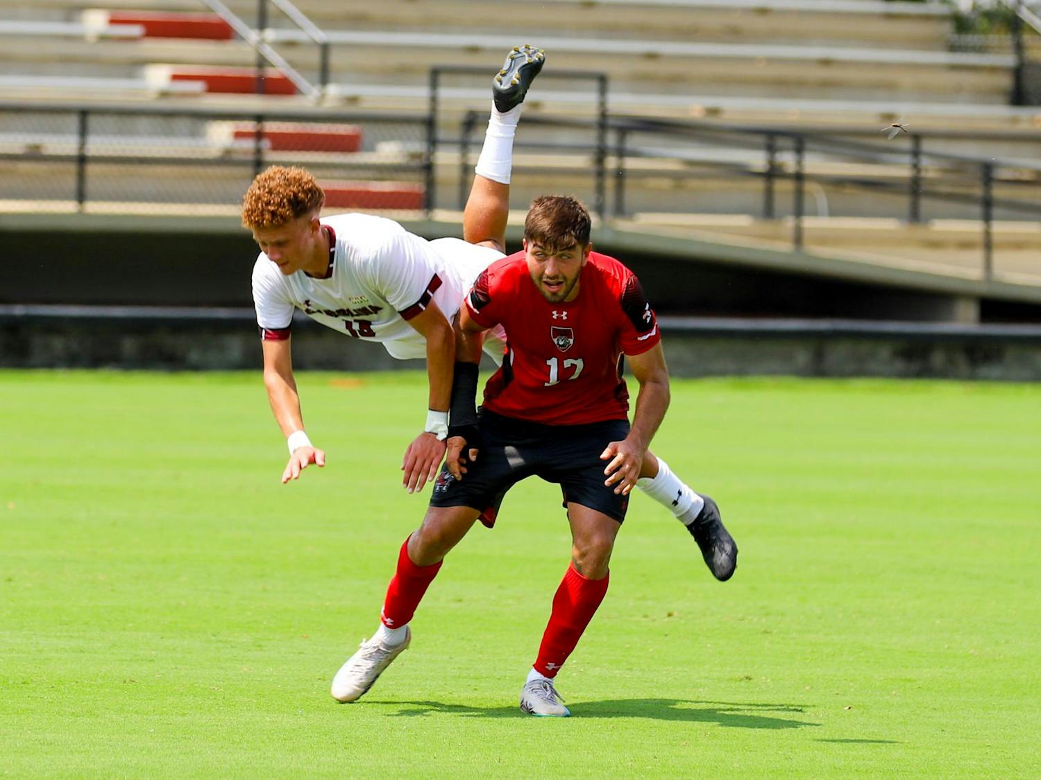 Freshman midfielder Jonah Biggar tumbles over a Gardner-Webb player after a sudden stop. Over the whole match, the Bulldogs totaled 15 fouls to the Gamecocks' 10.