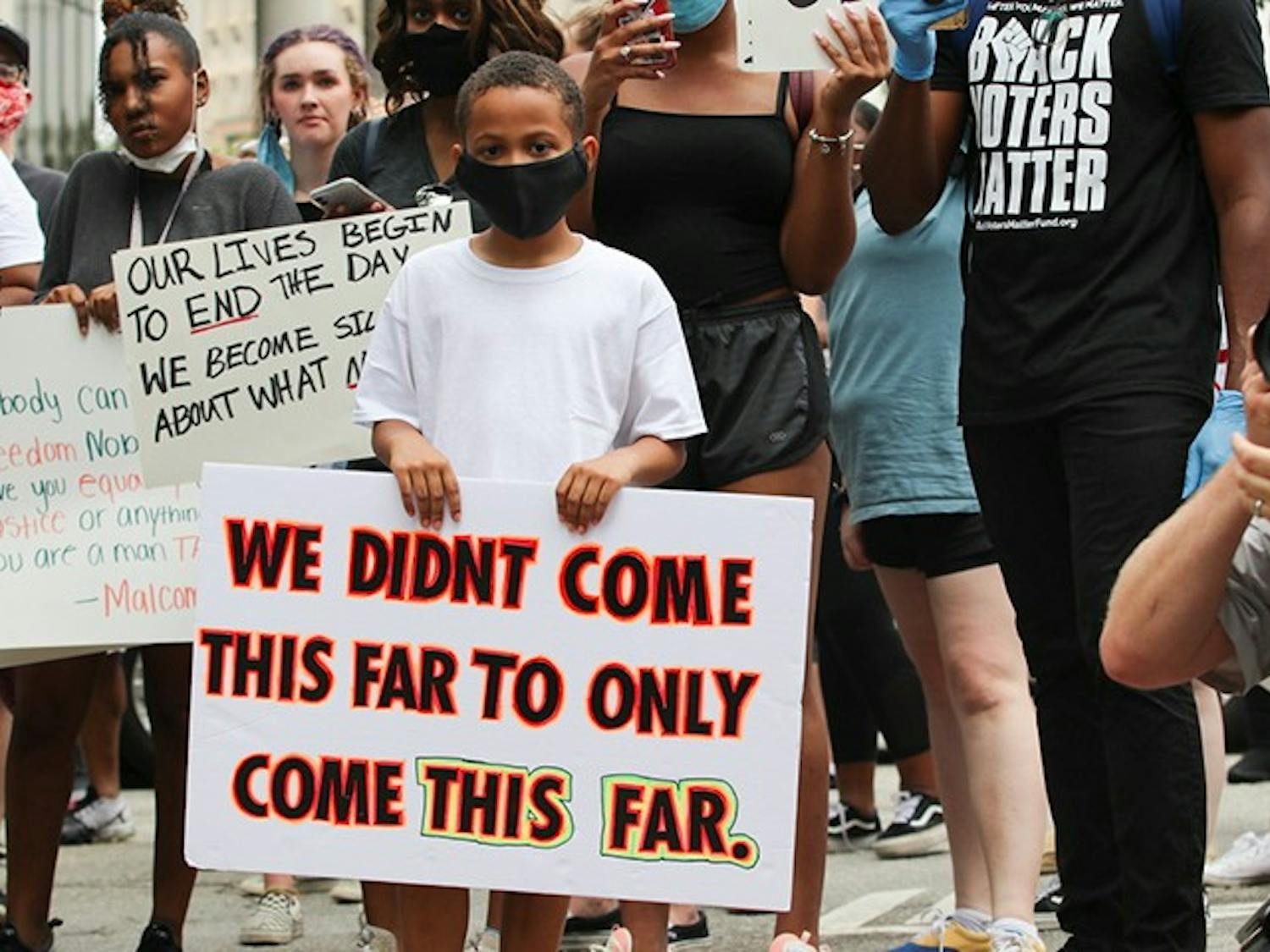 A young boy holds a sign at the “I Can’t Breathe” protest on Saturday. He was at the front of the march down Main Street.
