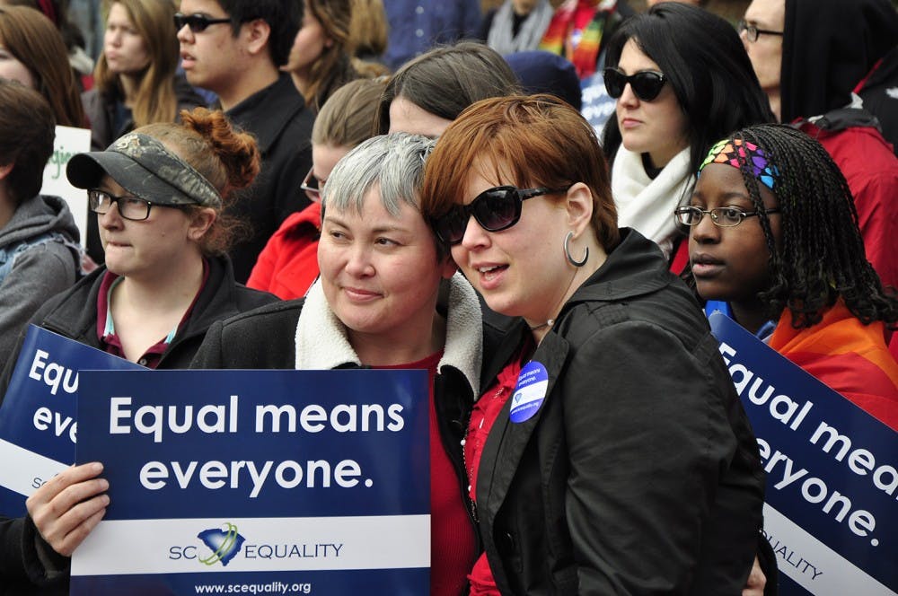 Same-sex couples at Tuesday's rally hold each other closely with hopes for change in the near future.