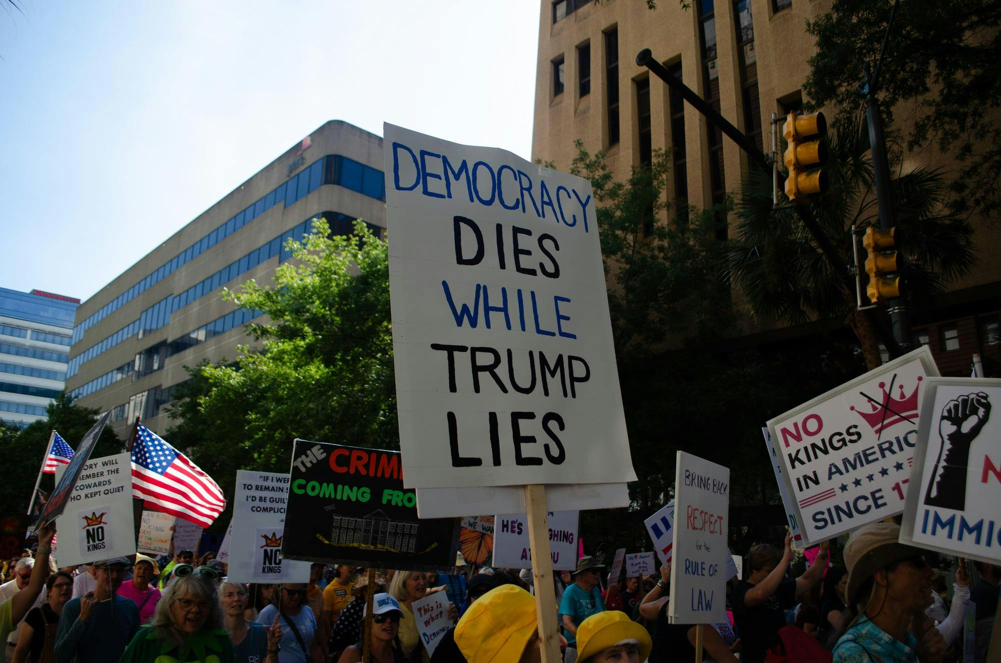 A protester holds a sign stating “Democracy dies while Trump lies” at a "No Kings" protest in Columbia, South Carolina on Oct. 18, 2025. The "No Kings" protests are broadly opposed to President Donald Trump and his policies.