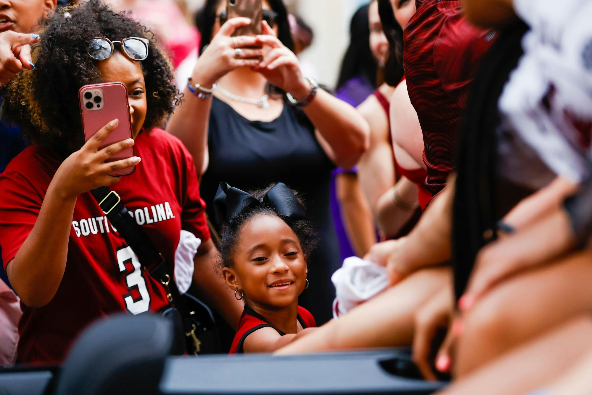 A young fan accepts a t-shirt from one of the Women’s Basketball players during a parade on April 13, 2022, in honor of the team’s national championship win. 