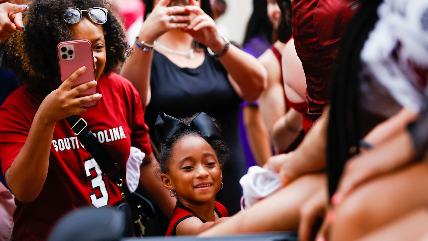 A young fan accepts a t-shirt from one of the Women’s Basketball players during a parade on April 13, 2022, in honor of the team’s national championship win. 