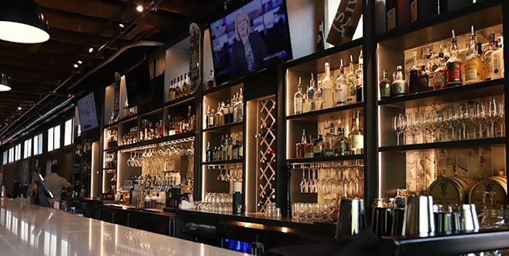 The bar inside Hendrix restaurant is stacked with different wines and liquors along with different glasses.