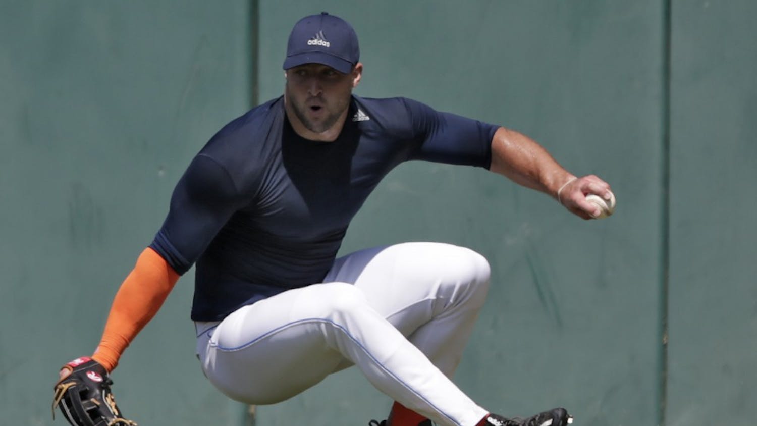 Former NFL quarterback Tim Tebow loses his footing as he fields a ball during outfield drills at USC's Dedeaux Field in Los Angeles during a private baseball tryout on Tuesday, Aug. 30, 2016. (Robert Gauthier/Los Angeles Times/TNS)