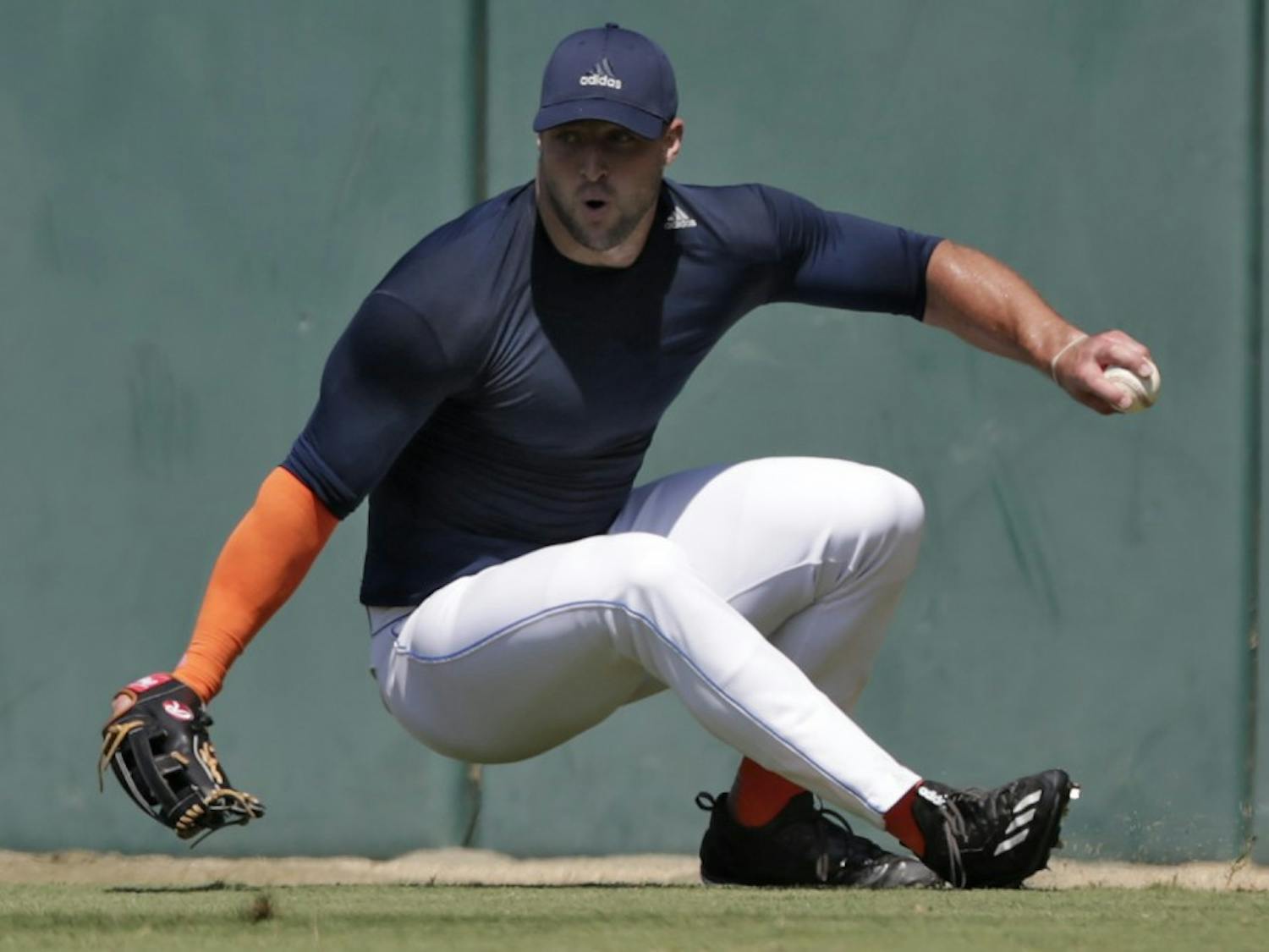 Former NFL quarterback Tim Tebow loses his footing as he fields a ball during outfield drills at USC's Dedeaux Field in Los Angeles during a private baseball tryout on Tuesday, Aug. 30, 2016. (Robert Gauthier/Los Angeles Times/TNS)