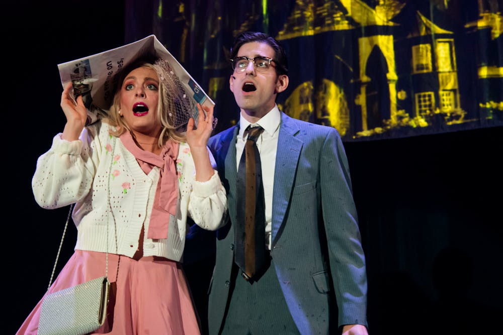 <p>College sweethearts Brad and Janet, played by Michael Hazin(right) and Katie Leitner(left), from the 'Rocky Horror Picture Show' stand in the rain before entering the doctor's mansion. &nbsp;</p>