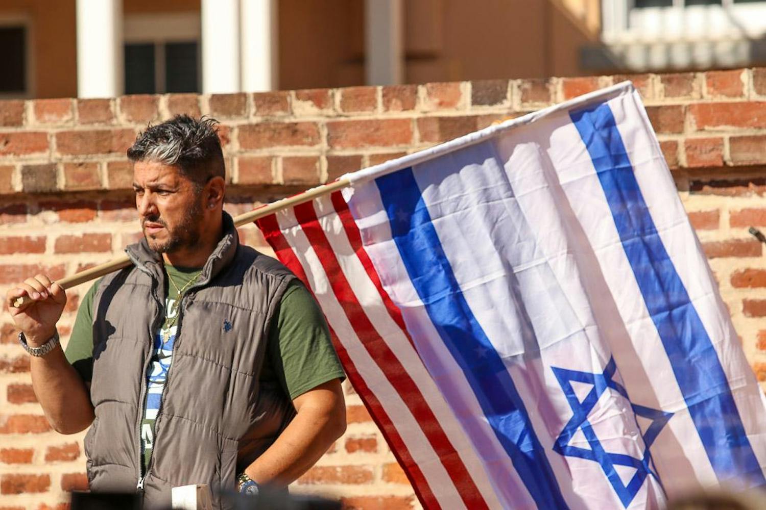 A pro-Israel rally attendee holds both the American and Israeli flags out on Greene Street during the pro-Israel rally on Dec. 7, 2023. Several rally-goers gathered on Greene Street, holding up flags after counter-protestors tore the flags down.