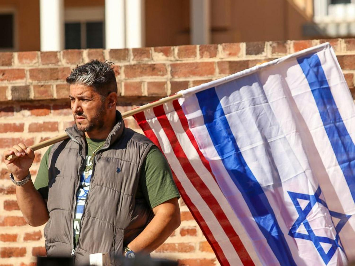 A pro-Israel rally attendee holds both the American and Israeli flags out on Greene Street during the pro-Israel rally on Dec. 7, 2023. Several rally-goers gathered on Greene Street, holding up flags after counter-protestors tore the flags down.